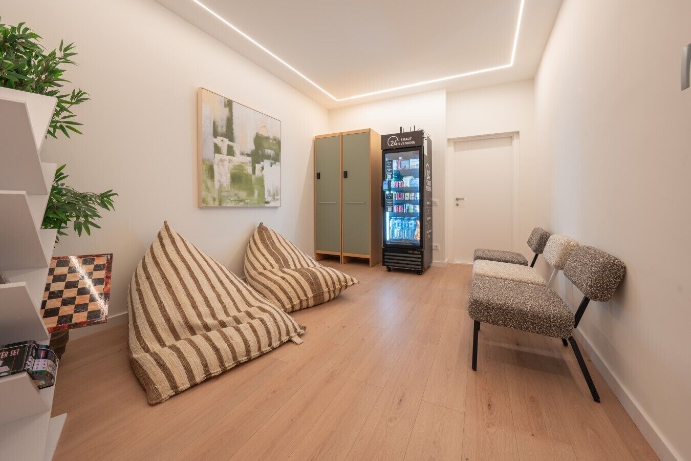 Un interior moderno con una zona de estar, una máquina expendedora y una puerta.