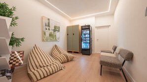 Ein modernes Interieur mit einer Sitzecke, einem Verkaufsautomaten und einer Tür.