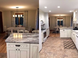 A kitchen with white cabinets, a granite countertop, and a patterned rug. - Beautiful Lakeside Cabin with a Stone Fireplace near Cornucopia, Wisconsin (Ashland)