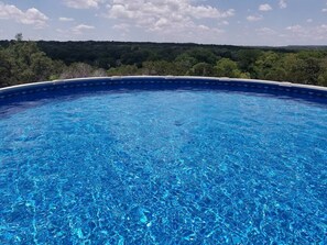 Piscina azul cristalina con vistas a un paisaje boscoso.