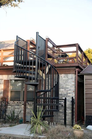 A modern building with a spiral staircase, a stone facade, and a metal fence.