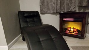A black leather ottoman, a fireplace, and a grey wall. - Idyllic Cottage Rental Perfect for an Outdoor Getaway in Killeen, Texas (Killeen)