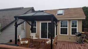 A deck with a covered seating area, a grill, and a sliding glass door to a house. - Idyllic Cottage Rental Perfect for an Outdoor Getaway in Killeen, Texas (Killeen)
