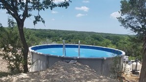A swimming pool with a view of a forested landscape. - Idyllic Cottage Rental Perfect for an Outdoor Getaway in Killeen, Texas (Killeen)