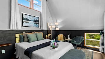 Een slaapkamer met een bed, nachtkastjes, een raam met uitzicht, een hanglamp en een spiegel.
