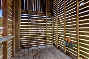 Una estructura de madera con un aro de baloncesto y una cesta de balones.