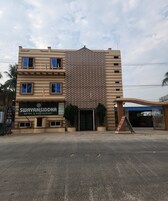 Un hotel con fachada estampada, un letrero que dice 'Swayamsiddha Hotel & Restaurant' y una entrada protegida por una reja.