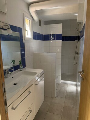 Ein modernes Badezimmer mit Waschbecken, Spiegel und Dusche.