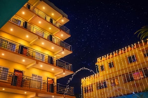 Un hôtel à plusieurs étages, doté de balcons, avec une vue imprenable sur le ciel étoilé.