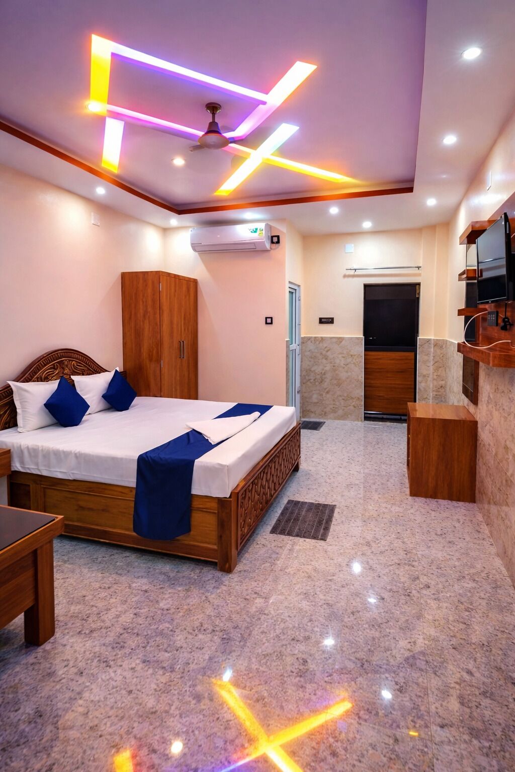 Une chambre d’hôtel équipée d’un lit, d’une armoire, d’une coiffeuse et d’un téléviseur.