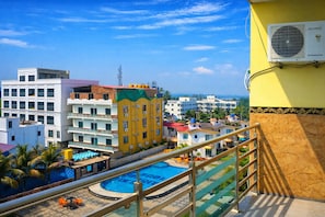 A hotel with a pool, balconies, and a view of the surrounding buildings. - DREAM BASANTI (Mandarmani)