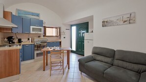Cocina compacta con una mesa de comedor y un sofá en la sala.