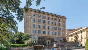 Ein mehrstöckiges Gebäude im klassischen Stil, mit einer symmetrischen Fassade, gleichmäßig verteilten Fenstern und einem zentralen Eingang.