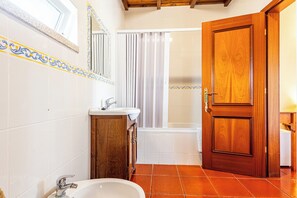Une salle de bain avec un lavabo, un miroir et une douche.