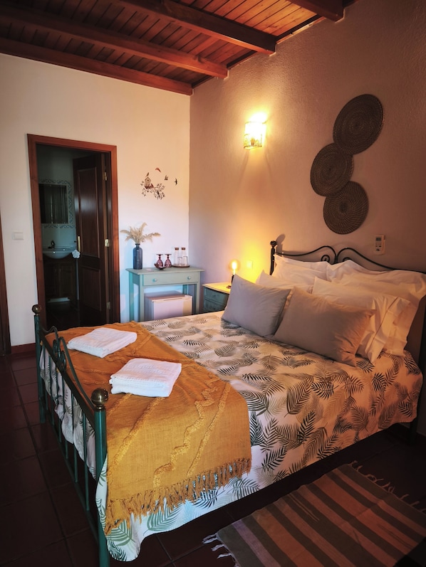 Une chambre à coucher comprenant un lit, une table de chevet, une lampe et un luminaire fixé au mur.