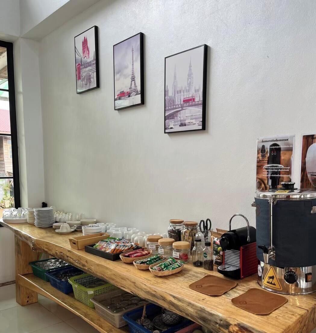 Ein reichhaltiges Buffet mit Tellern, Tassen und Gewürzen auf einer Holztischplatte, mit drei Stadtansichten an der Wand.