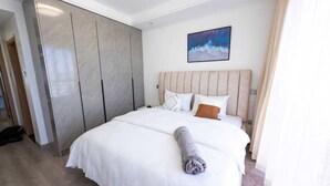 Quarto de hotel com uma cama grande, um guarda-roupa e um quadro na parede.