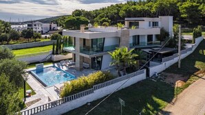 A modern two-story house with a swimming pool, surrounded by greenery and hills. - Villa Con Brio (Pomer)