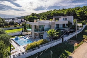A modern two-story house with a swimming pool, surrounded by greenery and hills. - Villa Con Brio (Pomer)