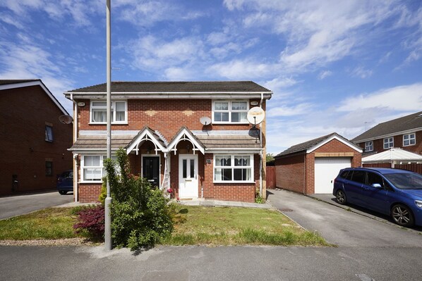A two-story brick house with a front porch, satellite dishes, and a parked car. - Host Stay - Urban Nest LIV (Liverpool)