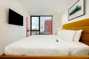 A hotel room with a bed, a TV, a window with a city view, and a framed picture on the wall. - w Urban 1BR w/ AC in the Heart of Cuauhtemoc (Mexico City)