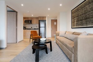 Ein modernes Wohnzimmer mit einer Couch, einem Couchtisch und einem Essbereich mit Stuhl und Tisch.
