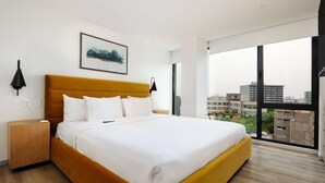 A modern hotel room with a large bed, a city view, and a framed artwork on the wall. - w Amazing 2BR w/ AC in the Heart of Cuauhtémoc (Mexico City)