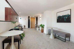 Eine moderne Hotelhalle mit einem runden Tisch, einer Bank und Topfpflanzen.