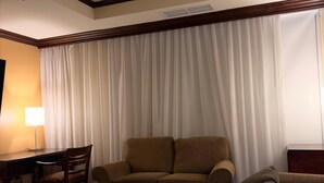 Una camera d'albergo con un letto, una scrivania, una sedia e un divano.