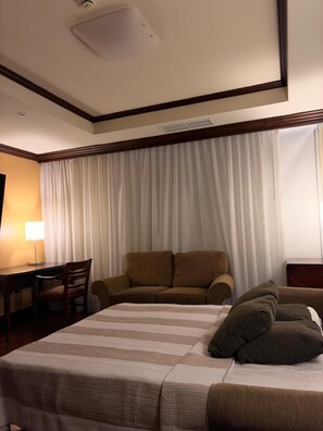 Ein Hotelzimmer mit einem Bett, einem Schreibtisch, einem Stuhl und einem Sofa.