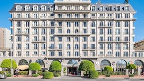 Ein mehrstöckiges Hotel mit einer symmetrischen Fassade, großen Fenstern und einem zentralen Eingang.