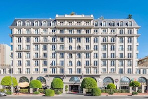 Ein mehrstöckiges Hotel mit einer symmetrischen Fassade, großen Fenstern und einem zentralen Eingang.