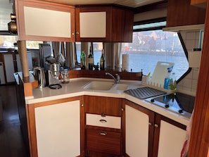 A compact kitchen with wooden cabinets, a coffee maker, a kettle, and a sink. - Beautiful accommodation in the center of Lübeck (Lübeck)
