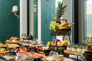 A buffet with various food items and a fruit display. - Hotel Eden (Budva)