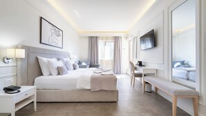 A modern hotel room with a large bed, bedside table, desk, chair, and a TV mounted on the wall. - Hotel Eden (Budva)