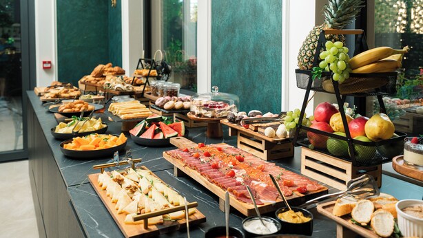 A buffet with various food items and a fruit basket. - Hotel Eden (Budva)
