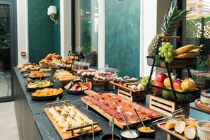 Un buffet proposant une variété de plats et un panier de fruits.