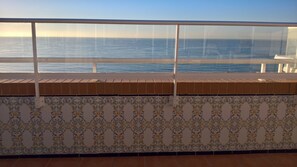 Ein Balkon mit Meerblick, Fliesenwände mit dekorativem Muster und einem Geländer.
