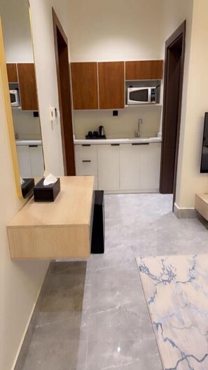 A modern kitchen with white cabinets, a microwave, and a sink. - Casa Residence Al Narjees (Riyadh, Al Narjis neighborhood)