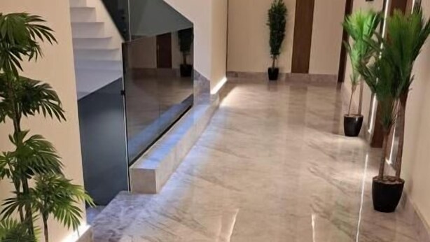 A hallway with marble flooring, potted plants, and a staircase. - Casa Residence Al Narjees (Riyadh, Al Narjis neighborhood)