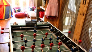 A foosball table in a room with wooden walls and a window. - Chalet Cannelle (La Chapelle-d'Abondance)