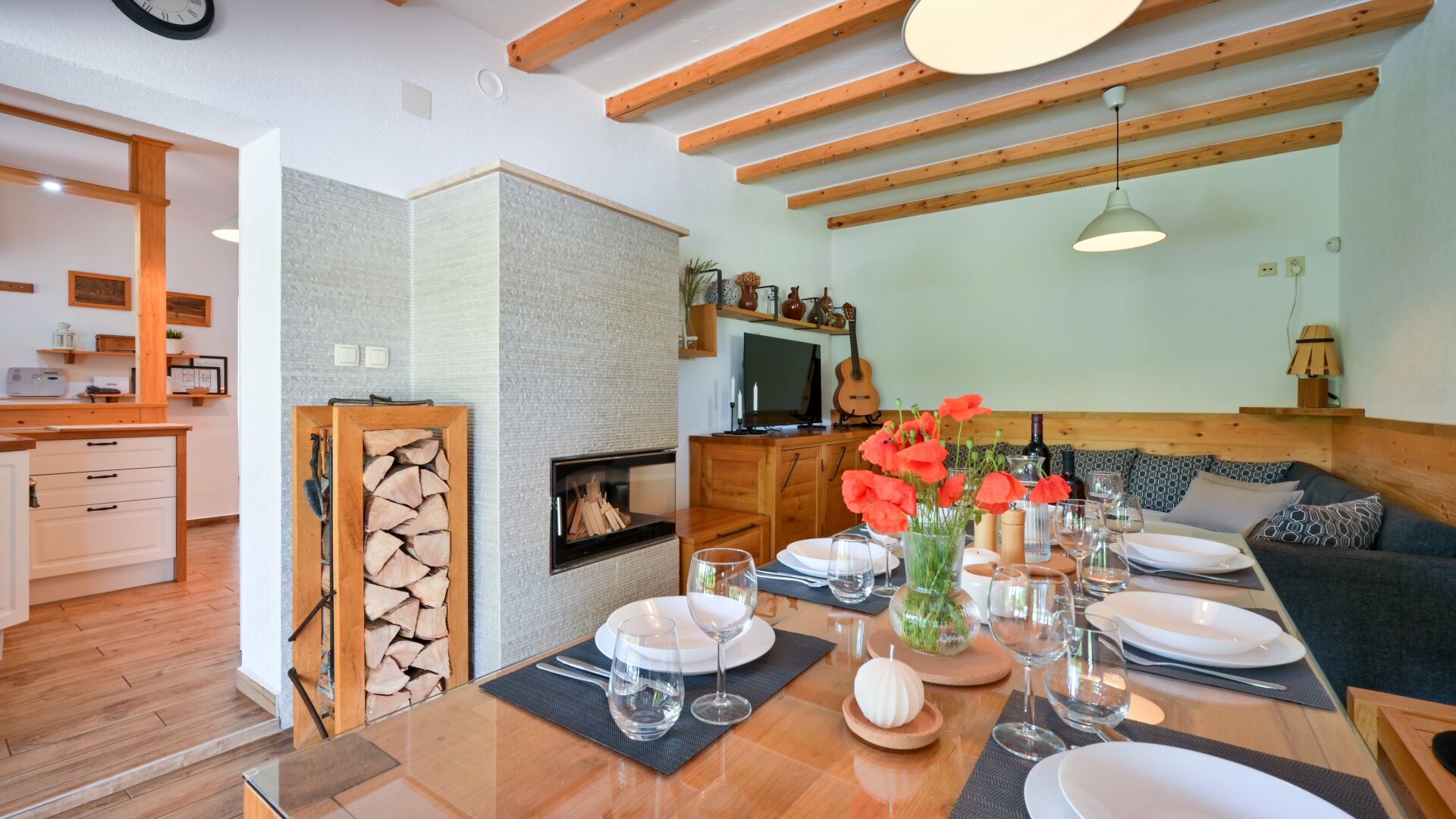 Comedor con mesa de madera dispuesta para cuatro personas, rodeado de un espacio de asientos acogedor.