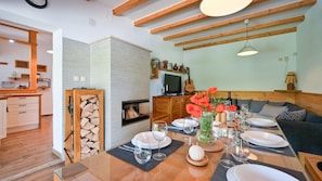 Comedor con mesa de madera dispuesta para cuatro personas, rodeado de un espacio de asientos acogedor.