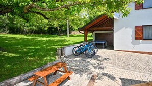 A covered outdoor area with a picnic table and bicycles parked.
