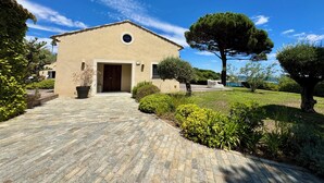 A building with a paved entrance, a large tree, and a clear blue sky. - La Voile - Beachfront family villa - Pool Direct beach access Saint-Tropez 5 min (Grimaud)