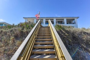 Eine Holztreppe führt zu einem weißen Gebäude mit einer amerikanischen Flagge.