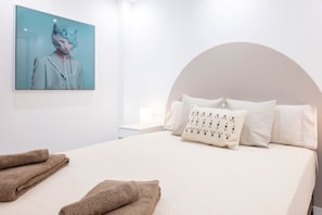 A neatly made bed with pillows and a blanket, a wall-mounted artwork, and a curved ceiling. - Beautiful 2-bedroom apart. with AC in enjoyable Los Cristianos 300m to the beach (Los Cristianos)