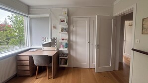 A room with a desk, chair, bookshelves, a mirror with lights, and a door. - Bright and eclectic flat in Reykjavík - walk everywhere (Reykjavík)