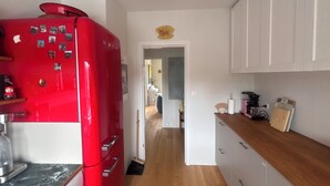 A kitchen with a red refrigerator, white cabinets, and a wooden countertop. - Bright and eclectic flat in Reykjavík - walk everywhere (Reykjavík)
