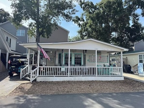 Ein eingeschossiges Haus mit Veranda, überdachtem Bereich und Garage.